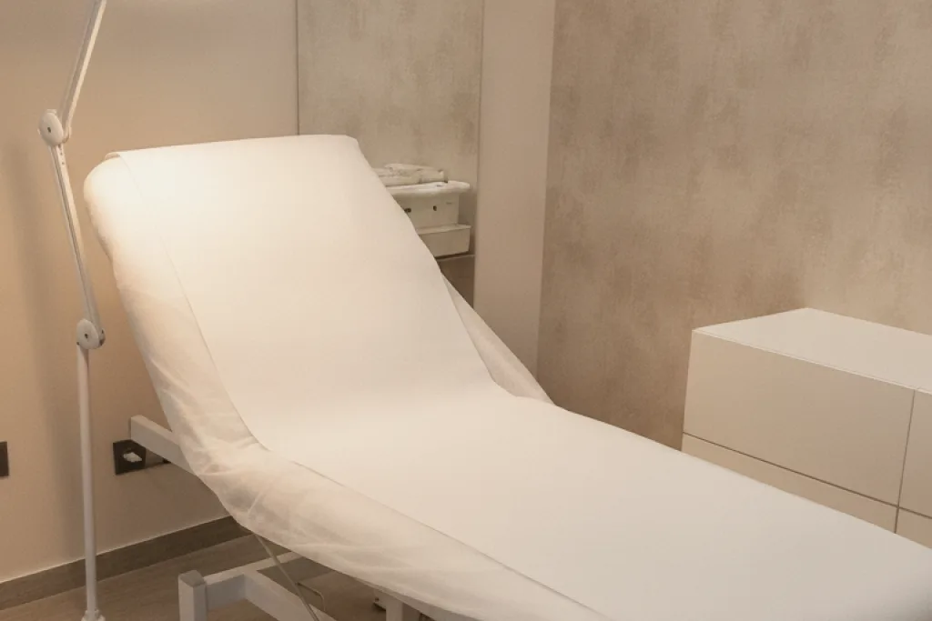 Cabina de tractaments d’AURA Clinics, amb la llitera preparada i protecció d’un sol ús